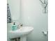Clean bathroom with a white pedestal sink, light blue walls, and minimalist decor at 514 Alamanni Ct, Graham, NC 27253