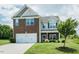 Charming two-story home featuring a brick and vinyl facade with a two car garage and well maintained lawn at 514 Alamanni Ct, Graham, NC 27253