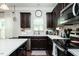 Bright kitchen with stainless steel appliances, dark cabinets, and a stylish grey rug at 514 Alamanni Ct, Graham, NC 27253