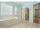 Bright bathroom features a tub, glass shower, and linen closet access at 5421 Brandy Bay Rd, Raleigh, NC 27613