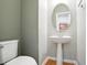 Traditional half bathroom with pedestal sink, oval mirror, and wood flooring at 5421 Brandy Bay Rd, Raleigh, NC 27613