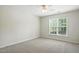 Neutral bedroom features carpet, window, and fan at 5421 Brandy Bay Rd, Raleigh, NC 27613