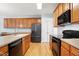Modern kitchen with wood cabinets, black appliances, and plenty of counter space at 5421 Brandy Bay Rd, Raleigh, NC 27613