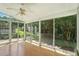Bright sunroom featuring hardwood floors, ceiling fan, and sliding glass doors to back yard at 5421 Brandy Bay Rd, Raleigh, NC 27613