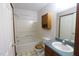 Well-lit bathroom featuring a bathtub, toilet, sink, and wooden cabinet at 622 Enon Rd, Oxford, NC 27565