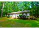 Beautiful single-story home with manicured lawn, small deck, black shutters, nestled in nature at 622 Enon Rd, Oxford, NC 27565