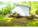 View of the home's backyard, with a small deck, siding, brick foundation, and lush green surroundings at 622 Enon Rd, Oxford, NC 27565