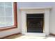 Close up of fireplace with white mantle, gas logs, gold trim and large window on the left at 622 Enon Rd, Oxford, NC 27565