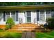 Inviting home entrance with brick steps, black handrails, manicured bushes, and black shutter accents at 622 Enon Rd, Oxford, NC 27565