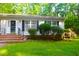 Well-maintained home featuring a landscaped front yard, brick steps, and charming black window shutters at 622 Enon Rd, Oxford, NC 27565
