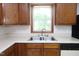 A kitchen featuring a stainless steel sink, wood cabinets and a white countertop at 622 Enon Rd, Oxford, NC 27565