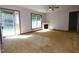 Bright, spacious living room with neutral carpet, white walls, fireplace, large window, and glass paneled door at 622 Enon Rd, Oxford, NC 27565