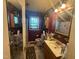 Small bathroom with red walls, patterned wallpaper, and a unique mirror at 625 Revell Rd, Selma, NC 27576