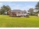 Expansive backyard with a deck and a stone fireplace on the patio, ideal for entertaining at 6708 Wavcott Dr, Fuquay Varina, NC 27526