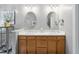 Bathroom with dual sink vanity, framed mirrors, wood cabinets, and modern fixtures at 6708 Wavcott Dr, Fuquay Varina, NC 27526