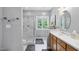 Bright bathroom featuring a glass shower, window, and vanity with modern finishes at 6708 Wavcott Dr, Fuquay Varina, NC 27526