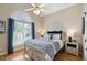 Bedroom with large window, white trim, stylish furniture, and wooden floors at 6708 Wavcott Dr, Fuquay Varina, NC 27526