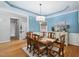 Elegant dining room featuring hardwood floors, a chandelier, and soft blue walls, perfect for gatherings at 6708 Wavcott Dr, Fuquay Varina, NC 27526