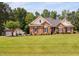 Charming brick home featuring a large lawn, complemented by a two-car garage and an array of mature trees at 6708 Wavcott Dr, Fuquay Varina, NC 27526