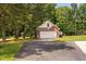 Detached garage with a brick facade and ample parking space, situated in a lush, wooded area at 6708 Wavcott Dr, Fuquay Varina, NC 27526