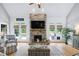 Bright living room with a stone fireplace, vaulted ceiling, hardwood floors, and natural light from outdoor views at 6708 Wavcott Dr, Fuquay Varina, NC 27526