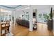 Open-concept living room featuring hardwood floors, a stone fireplace, and seamless connection to an outdoor balcony at 6708 Wavcott Dr, Fuquay Varina, NC 27526