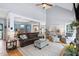 Bright, open living room with hardwood floors, vaulted ceiling, stone fireplace, and seamless flow to dining and kitchen areas at 6708 Wavcott Dr, Fuquay Varina, NC 27526