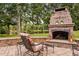 Inviting outdoor stone fireplace with seating, perfect for relaxing evenings by the lake at 6708 Wavcott Dr, Fuquay Varina, NC 27526