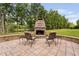 Outdoor patio with stone fireplace and seating area overlooking the lake and manicured lawn at 6708 Wavcott Dr, Fuquay Varina, NC 27526