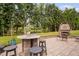 Entertain on the outdoor patio, featuring seating, fireplace, and scenic views of the lake and trees at 6708 Wavcott Dr, Fuquay Varina, NC 27526