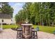 Lovely backyard patio features an outdoor table and chairs overlooking lush lawn and serene trees at 6708 Wavcott Dr, Fuquay Varina, NC 27526