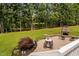Beautiful backyard patio features a fireplace and seating area overlooking mature trees and the lake at 6708 Wavcott Dr, Fuquay Varina, NC 27526