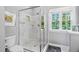 Modern bathroom featuring a glass shower with tiled walls and a view from the window at 6708 Wavcott Dr, Fuquay Varina, NC 27526