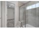 Bathroom walk-in shower featuring seat, window and grey tiled walls at 700 Ben Ledi Ct, Raleigh, NC 27603