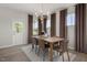Elegant dining area with modern lighting, a wooden table, and large windows at 700 Ben Ledi Ct, Raleigh, NC 27603