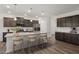 Stylish kitchen featuring a spacious island with bar seating, sleek appliances, and elegant dark wood cabinetry at 712 Ben Ledi Ct, Raleigh, NC 27603
