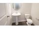 Elegant powder room features a round mirror and modern pedestal sink at 713 Traditions Grande Blvd, Wake Forest, NC 27587