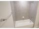 Clean bathroom featuring a white bathtub, gray tiled shower, and chrome fixtures at 713 Traditions Grande Blvd, Wake Forest, NC 27587
