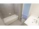 Bright bathroom with white tub and vanity complemented by modern gray tiles at 713 Traditions Grande Blvd, Wake Forest, NC 27587