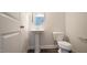 Modern powder room featuring a pedestal sink and a sleek, round mirror at 713 Traditions Grande Blvd, Wake Forest, NC 27587