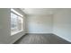 Bright, spacious living room features large windows and sleek gray wood floors at 713 Traditions Grande Blvd, Wake Forest, NC 27587
