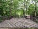 Wood back deck with a hot tub surrounded by mature trees and foliage at 820 Parkridge Dr, Clayton, NC 27527