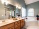 Bathroom showcasing a large mirror, double vanity, garden tub, and separate shower at 820 Parkridge Dr, Clayton, NC 27527