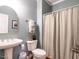 Cozy bathroom with a pedestal sink, toilet, and decorative shower curtain at 820 Parkridge Dr, Clayton, NC 27527