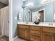 Well-lit bathroom featuring a double vanity with wood cabinets and a large mirror at 820 Parkridge Dr, Clayton, NC 27527