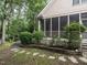 Exterior view of a screened-in porch surrounded by mature landscaping at 820 Parkridge Dr, Clayton, NC 27527