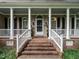 Inviting covered front porch with brick steps and classic white columns at 820 Parkridge Dr, Clayton, NC 27527