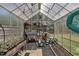 The interior of a greenhouse with shelving units and fan at 85 Willard Wood Run, Benson, NC 27504