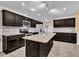 Modern kitchen featuring dark cabinets, a large island, and stainless steel appliances at 85 Willard Wood Run, Benson, NC 27504