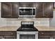 Close up of the kitchen stove, microwave, and granite countertop at 85 Willard Wood Run, Benson, NC 27504